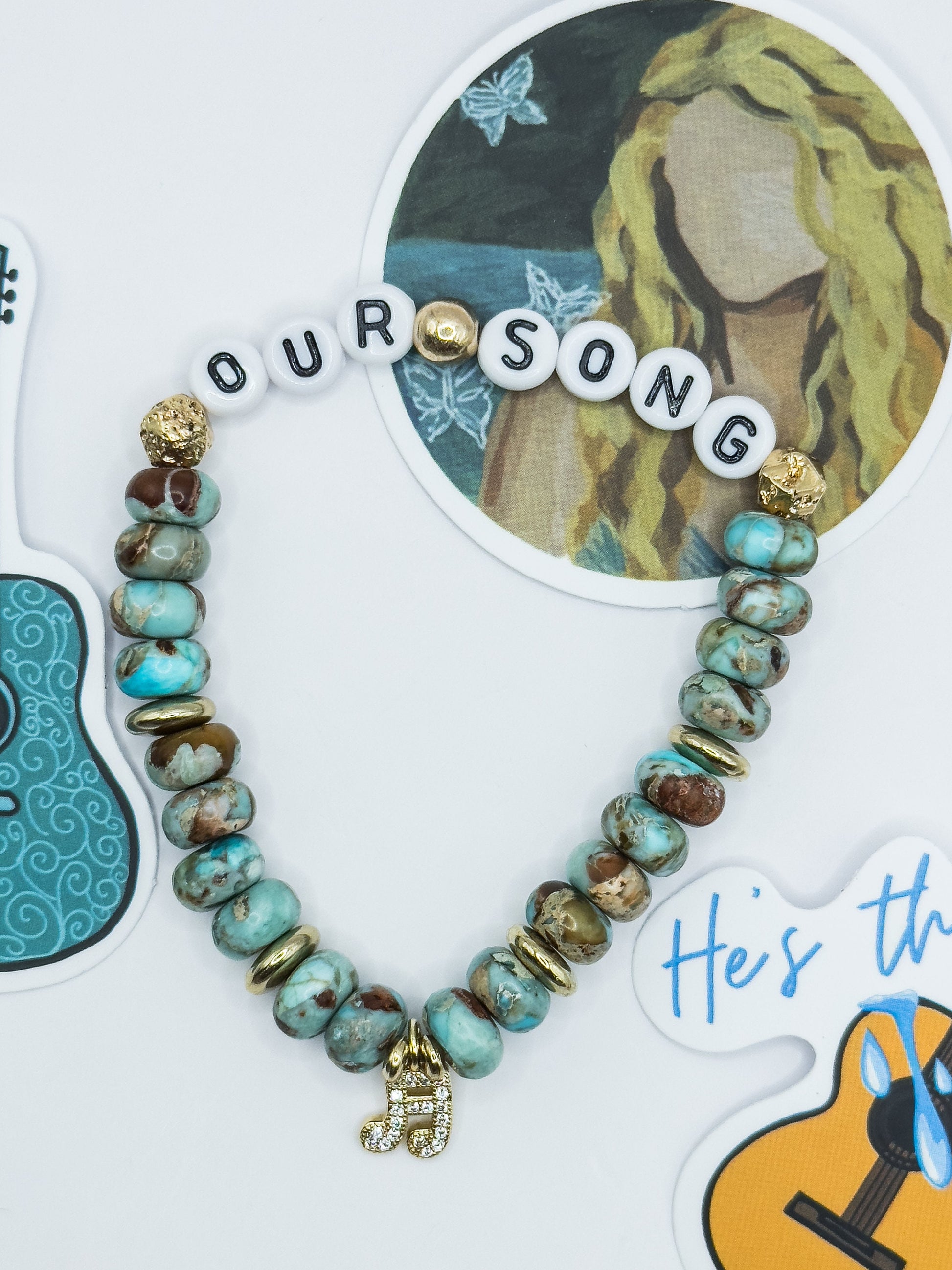 Beaded bracelet with 'OUR SONG' charm on a decorative card with guitar and butterfly design.